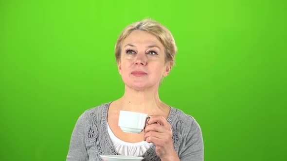 Woman Is Drinking Tea. Green Screen alt