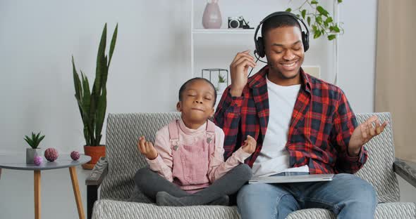 Funny Caring Afro American Daughter Little Girl Sitting with Dad on Sofa Closes Laptop of Busy alt