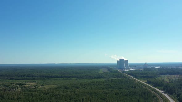 Smoking Cooling Towers at Nuclear Power Plant in Forest with Road. Aerial View alt