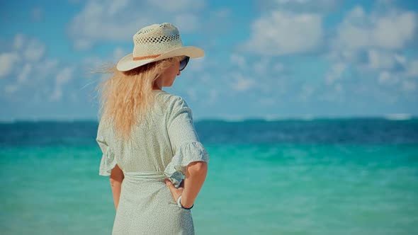 Woman Relaxing On Bahamas Flowing Dress Blowing In Wind. Travel Mood Wind Blows Dress On Ocean. alt