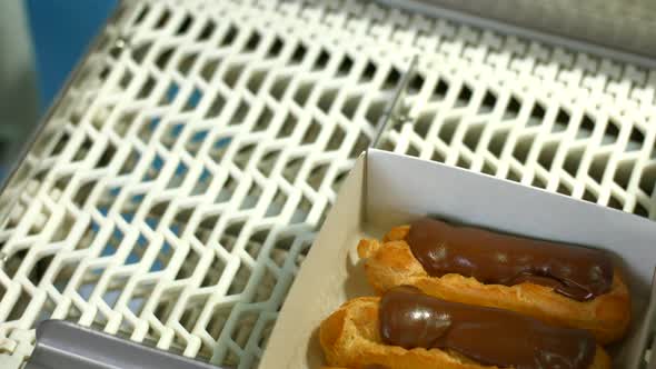Eclair Boxes on Conveyor Belt. alt