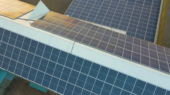 Blue photovoltaic solar panels mounted on building roof for producing clean ecological