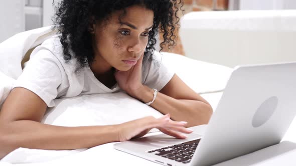 Headache Frustrated AfroAmerican Woman Working on Laptop in Bed alt
