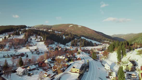 The Train Rides Through the Winter Village to the Bridge