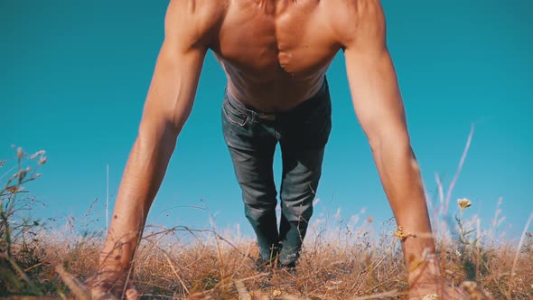 Young Athletic Man with a Bare Torso Performs Push-ups with Claps on Nature. Slow Motion alt