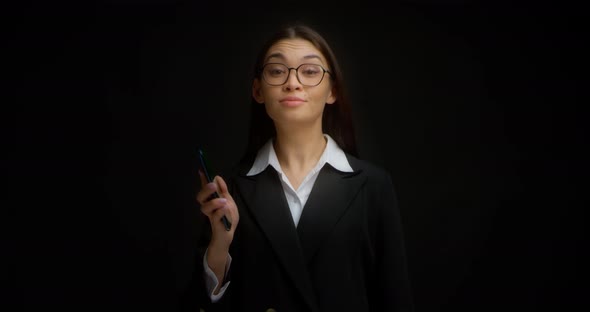 Business Woman Shows a Phone with a Vertical Green Screen for Copying