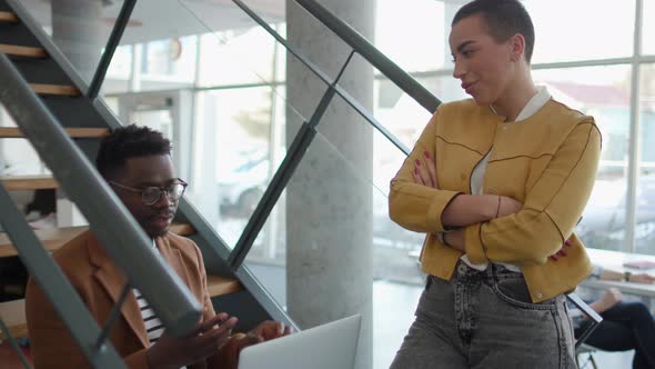 Handsome young African American business man and short hair woman working on laptop