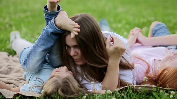 Woman with Children Lies in the Meadow and Have Fun