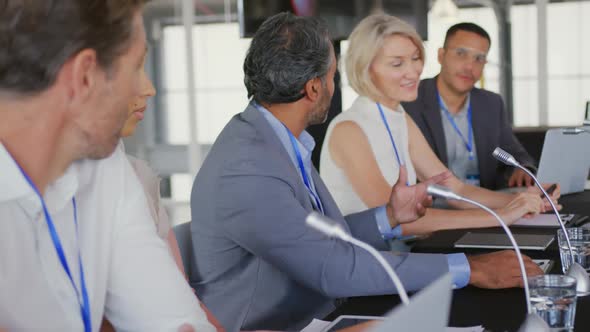A panel of business delegates talking at a conference alt
