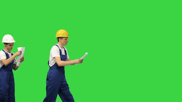 Three Young Construction Workers in Hardhats Passing on Documents While Doing a Silly Walk in a Row alt