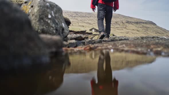 Man Traveling Alone Walking Past the Stream and Towards the Hill alt