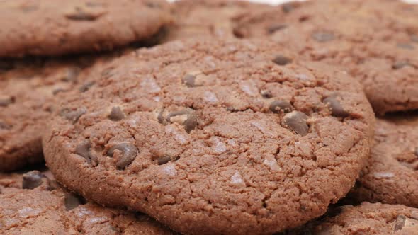 Lot of chocolate cookies tasty biscuits on pile food  background 4K 2160p 30fps tilting footage - Sl alt