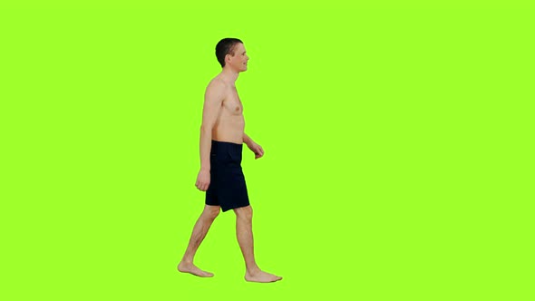 Young Shirtless Man in Shorts Walking Barefoot