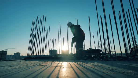 One Man Uses a Drill on a Construction Site alt