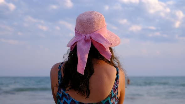 Woman in Hat Watching the Sea at the Beach