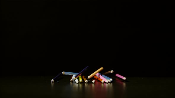 Coloring pencils falling on a black surface, Ultra Slow Motion alt
