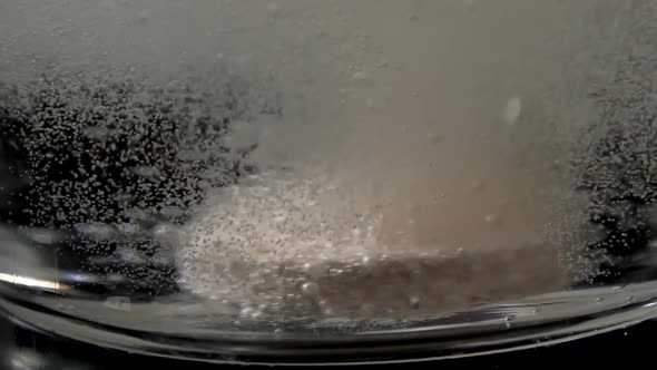 Effervescent Tablet Falling in a Glass of Water