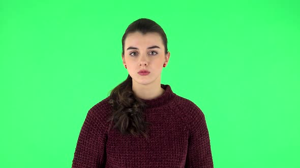 Girl Listens To Information Looking at Camera, Is Shocked and Very Upset. Green Screen alt