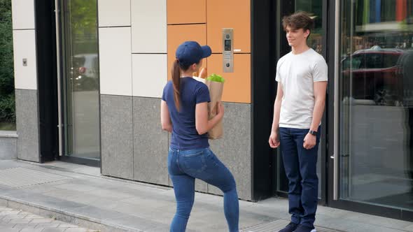 Smiling Food Delivery Woman Courier with Paper Bag of Groceries Deliver Order alt