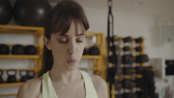 Young woman lifting weights in gym