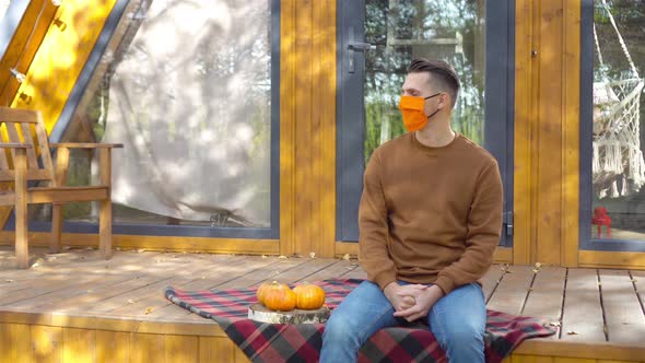Man in Mask on the Terrace in Autumn