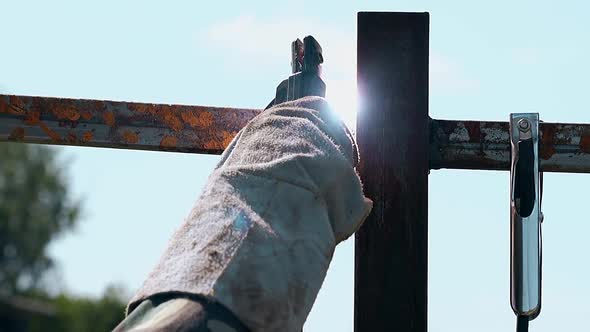 Closeup Welder in Special Gloves Fixes Carcass of Fence alt