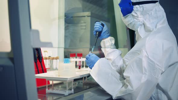 Researcher in a Hazmat Suit Is Working with Chemicals alt