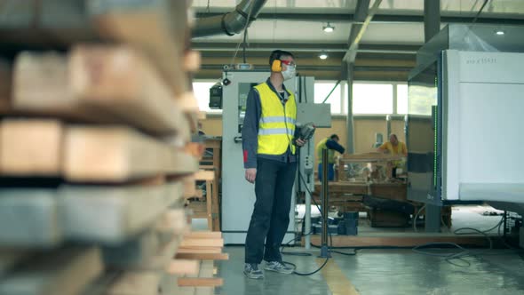 One Engineer in Uniform Works at Woodworking Plant alt