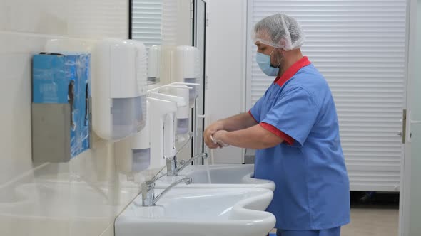 The doctor washes his hands with soap and running water
