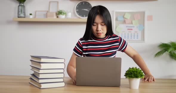 Portrait of Asian schoolgirl studying online via laptop alt