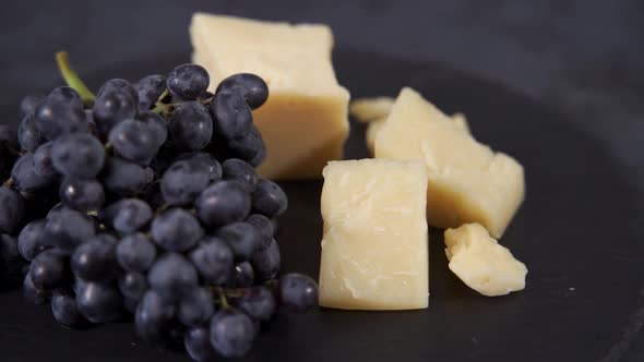 Delicious Cheese and Dark Grapes Lie on the Table