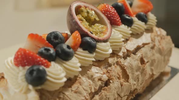 Meringue Roll with Fruits and Berries Rotates on a Platter