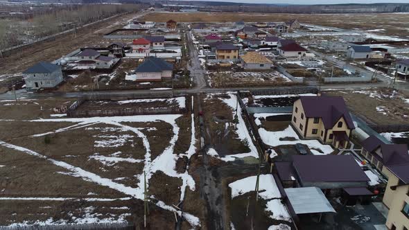 A father and his young son ride ATVs on a dirt road with puddles in village 04 alt