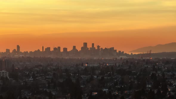 Aerial trucking of touristic Vancouver city skyline at sunset with colorful orange sky, British Colu alt