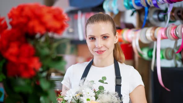 Portrait of Young Florist Female Beautiful Cheerful Woman Looks at the Camera and Smiles  alt