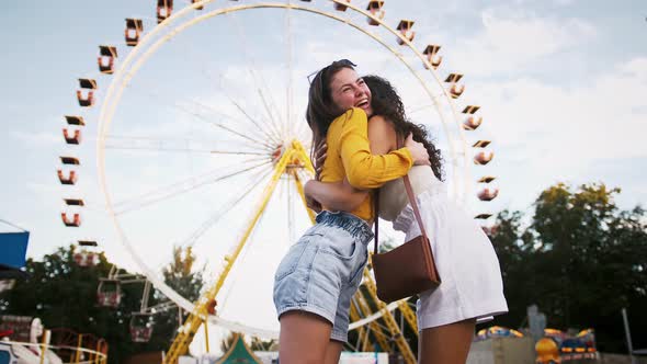 Two Young Women are Smiling Hugging Each Other Talking and Rejoicing Their Meeting While Posing in alt