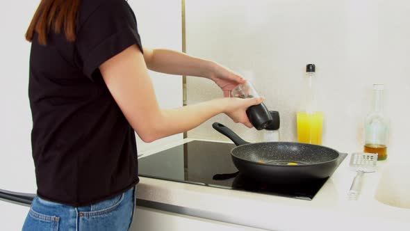 Woman Putting Fried Eggs on Plate