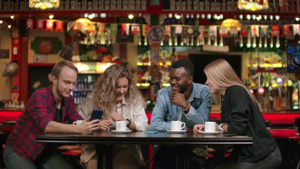 AfroAmerican Man with Friends in a Cafe Laughs and Spends Time in a Cheerful Company and Smiling alt