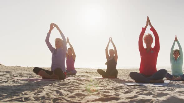 Athletic women performing yoga in the beach alt
