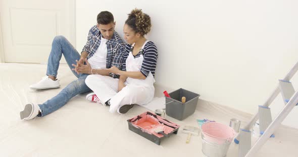 Black Couple Relaxes After Long Day of Painting alt