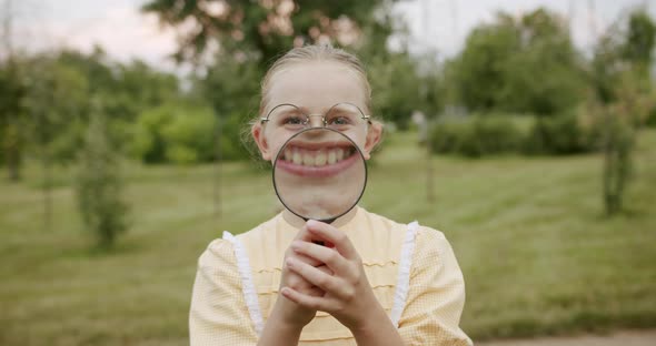 Loupe Fun Children Smile with a Magnifying Glass Enjoy He Makes Big Teeth alt