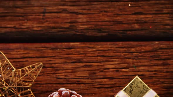 Pine cones with gift box and star shape ornament on a plank alt