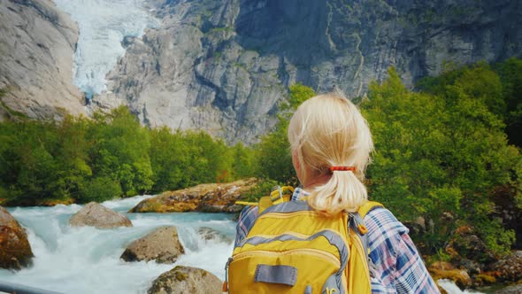Active Woman on a Trip To Norway. Enjoys the Beautiful Briksdal Glacier alt