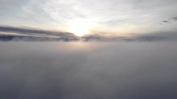 Incredible Aerial View Shot Above Swirling Fog and Clouds at Sunset in the Mountains alt