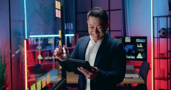 Businessman Getting Good News on Tablet pc while working overtime alt