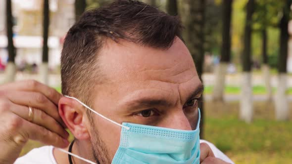 Closeup of the Face of a Young Man Wearing a Medical Mask alt