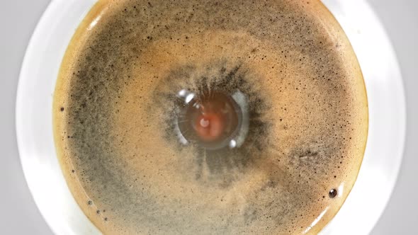 Super Slow Motion Detail Shot of Coffe Drop Falling Into Fresh Espresso at 1000 Fps alt
