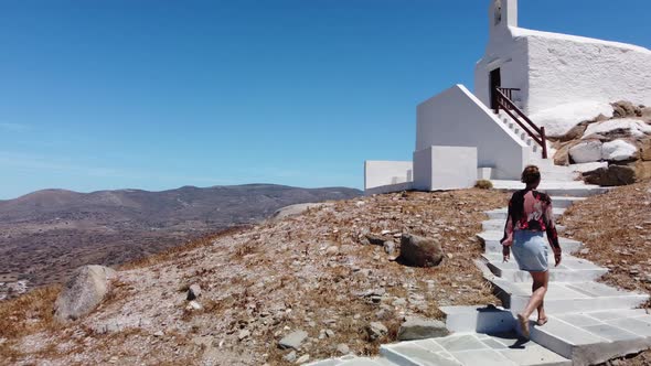 Aerial view from the top of Chora Village, Greece. Woman walks to the church alt