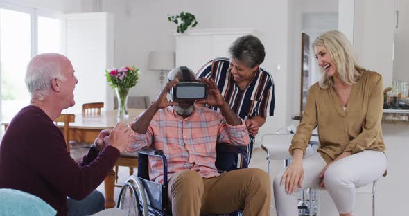 Two diverse senior couples sitting on a couch disabled african american man is using vr googles alt