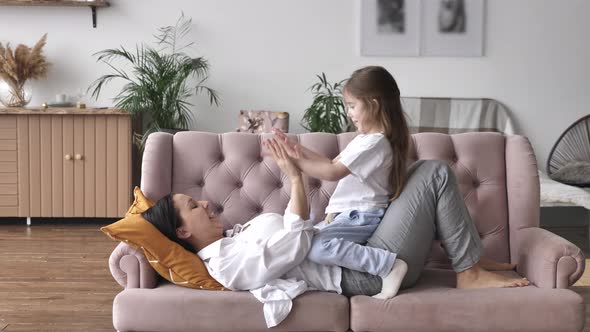 Young Mother and Child Girl Clap Hands Together Mom and Daughter Playing at Home alt